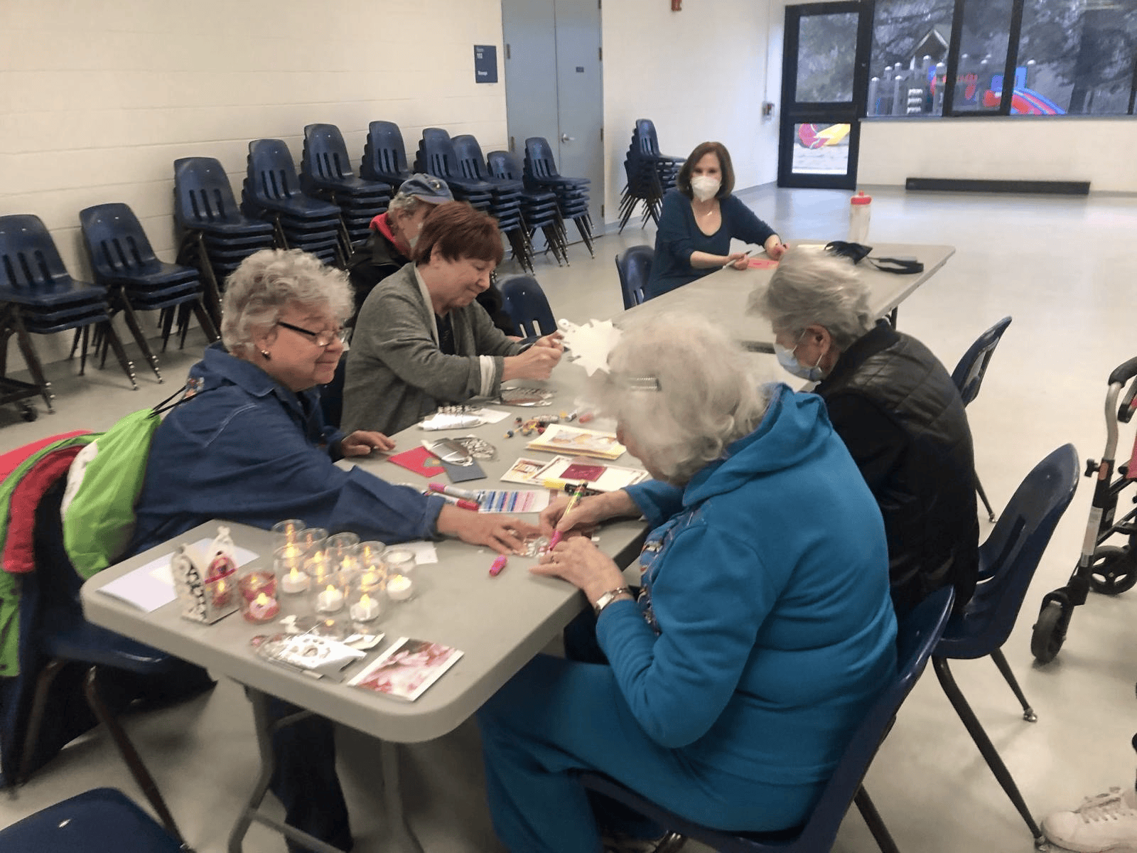 Older adults working together on jewellery and candle crafts